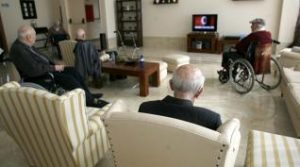 Personas mayores viendo la televisión en residencia usando el mando a distancia SIM 1 para personas mayores y hoteles