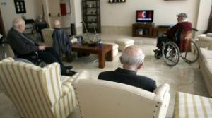 Personas mayores viendo la televisión en residencia usando el mando a distancia SIM 1 para personas mayores y hoteles