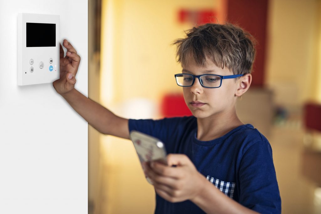 Niño usando monitor VEO de Fermax y su aplicación móvil Blue Fermax